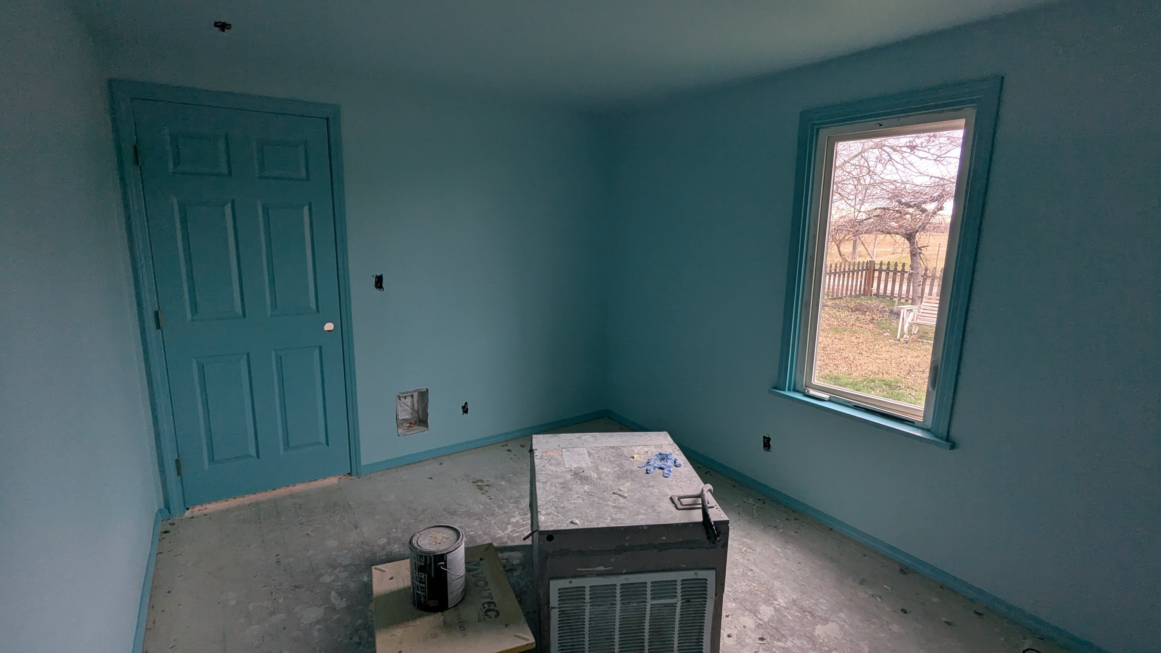 Freshly painted room with teal door and trim detail